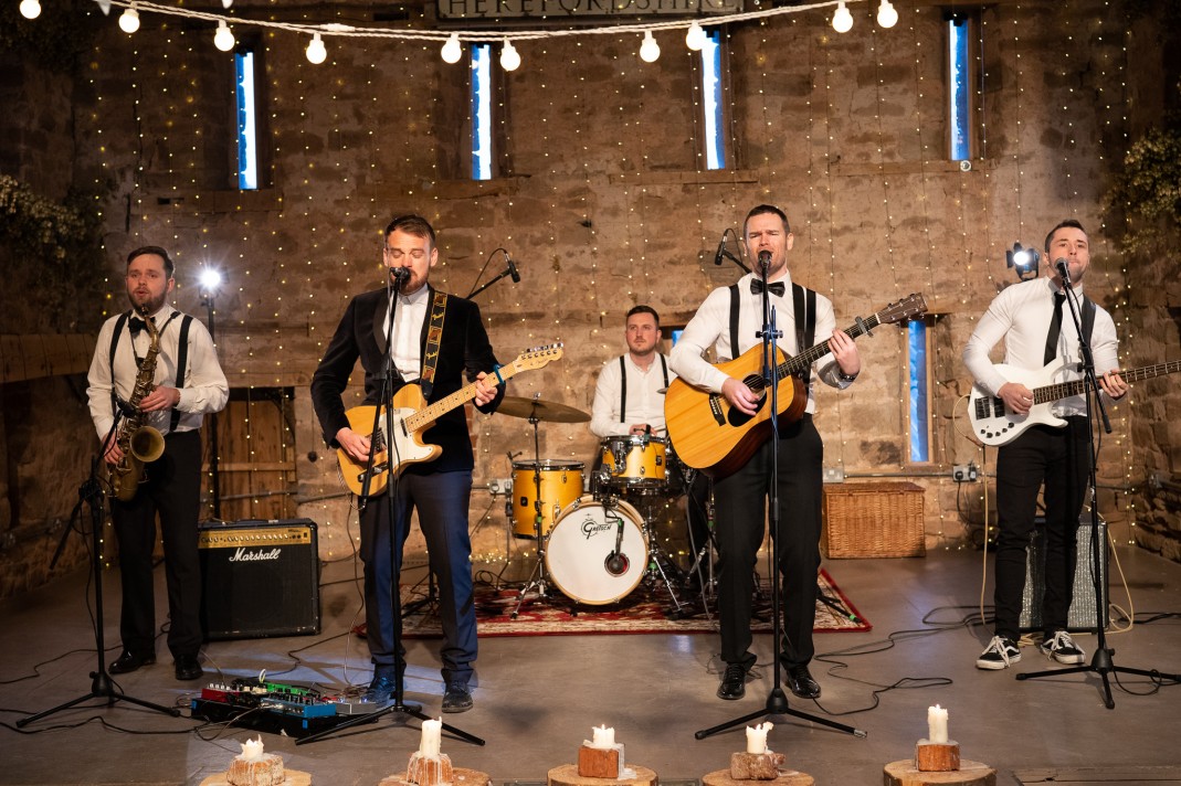 Band performing with string lights in background