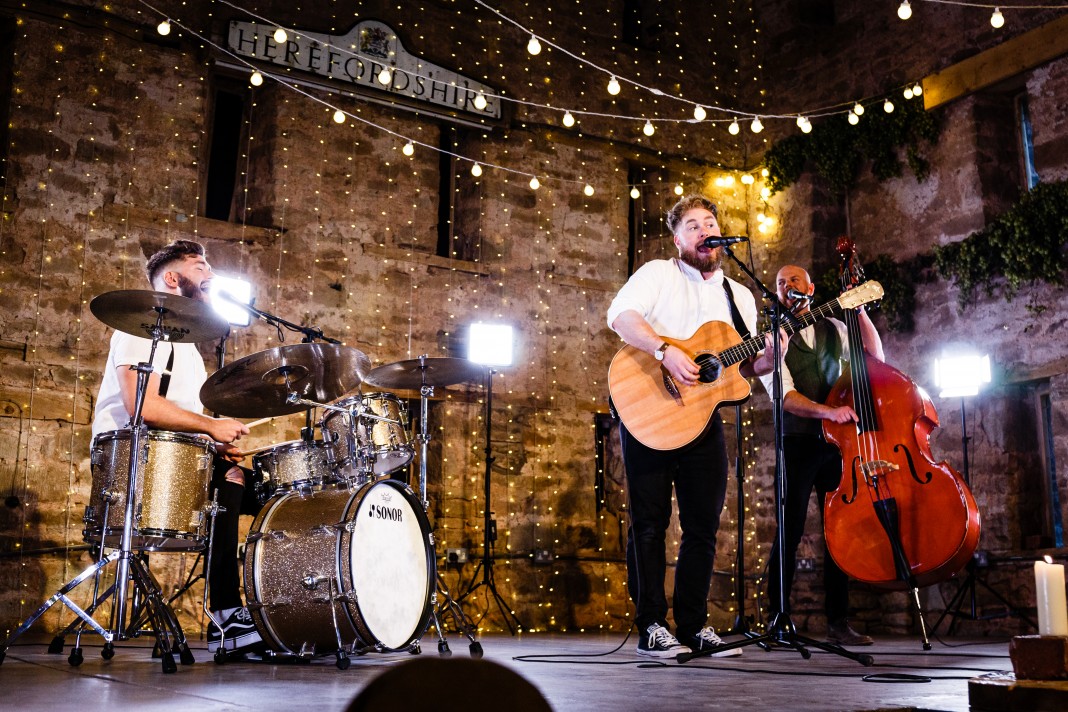 The band performing with a backdrop of fairy lights