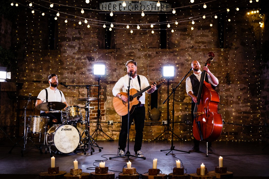 The band performing with a backdrop of fairy lights