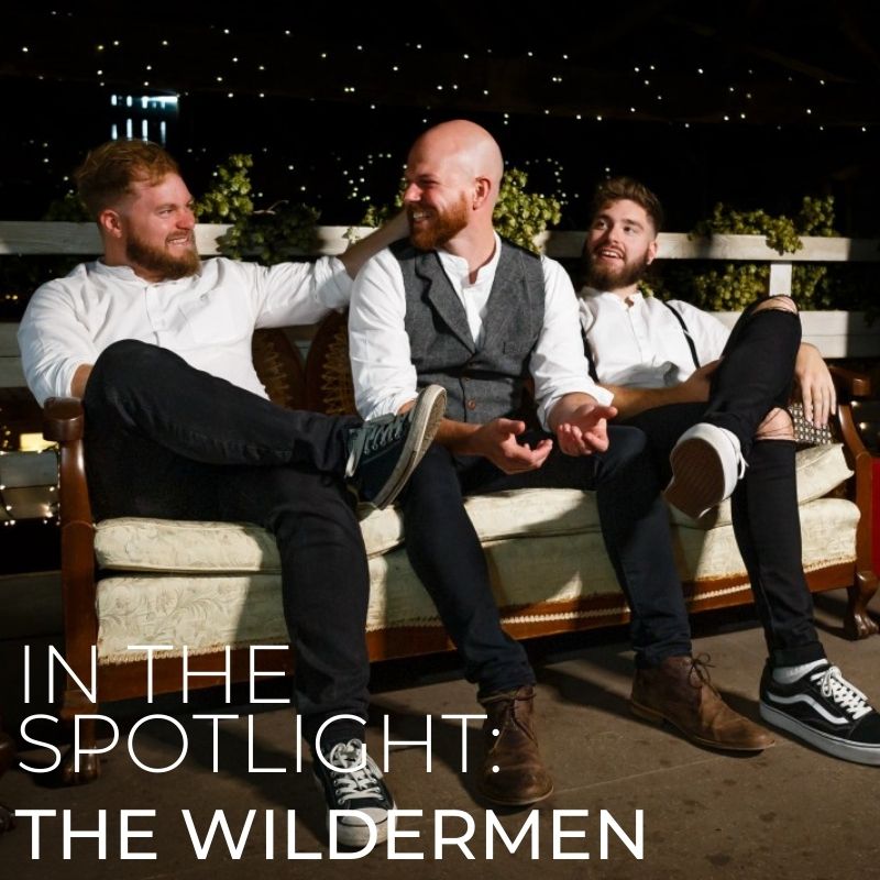 The band members sitting on a sofa outside at night with text layered on top saying 'In the spotlight: The Wildermen'