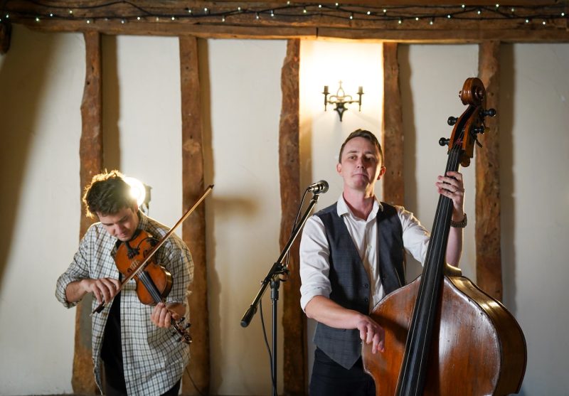 the bassist and optional fiddle player performing live